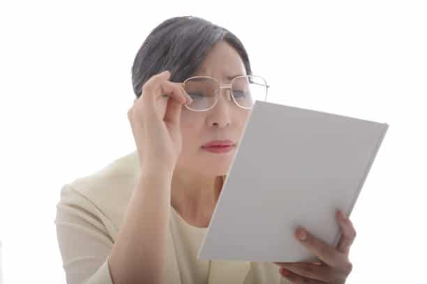 Femme d'une quarantaine d'années qui porte des lunettes pour presbyte pour lire